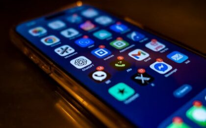 Smartphone screen showing various app icons with notification badges in low light.